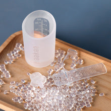Load image into Gallery viewer, Silicone mold with measurement markings on a wooden surface with clear silicone beads and a small mold.